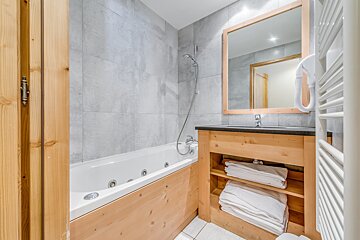 A bathroom with a bathtub a sink and a mirror