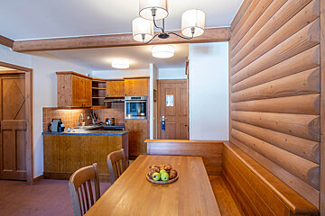A kitchen with a wooden table and chairs and a door that says ' hotel ' on it