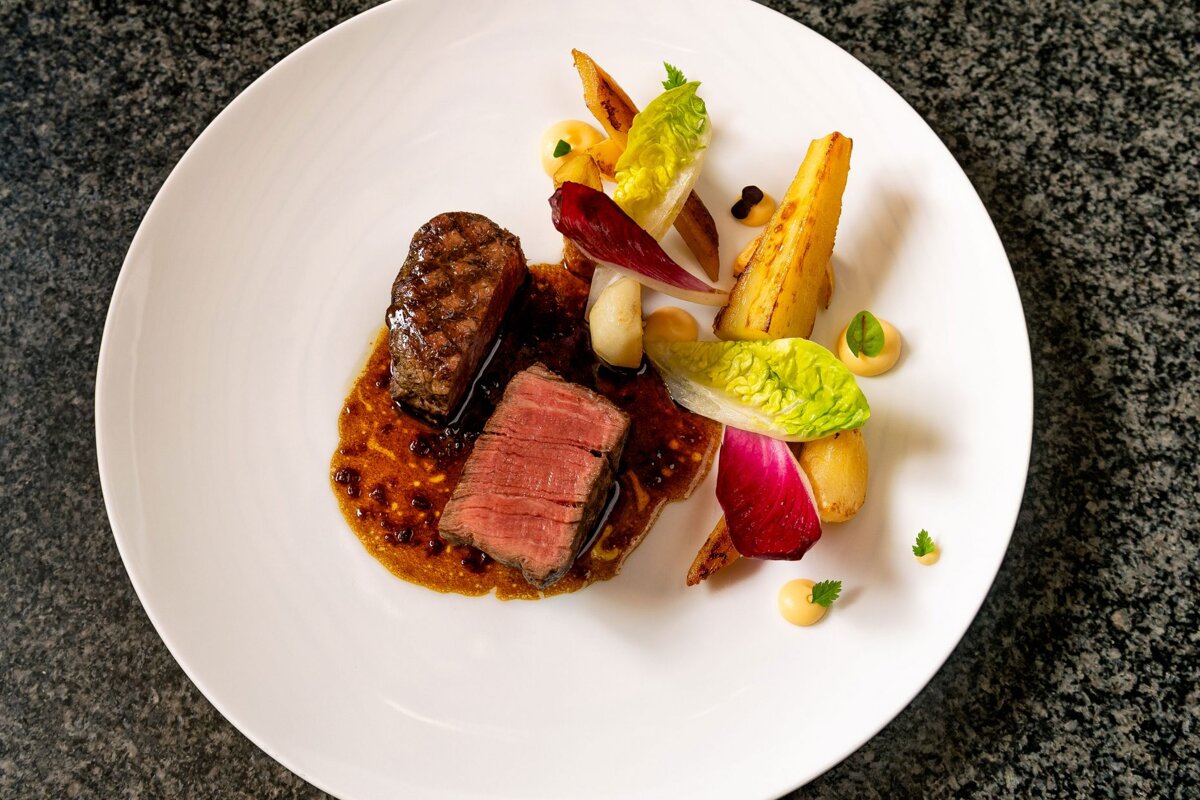 A white plate with meat and vegetables on it