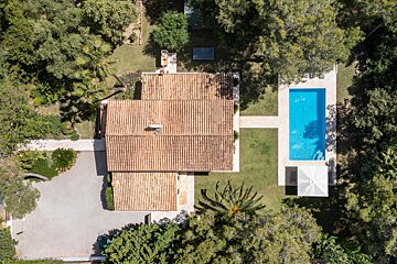 An aerial view of a house with a large swimming pool