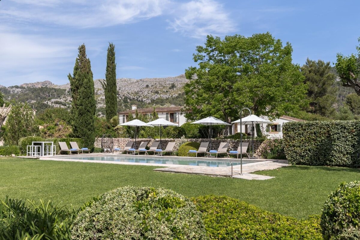 A large swimming pool surrounded by chairs and umbrellas