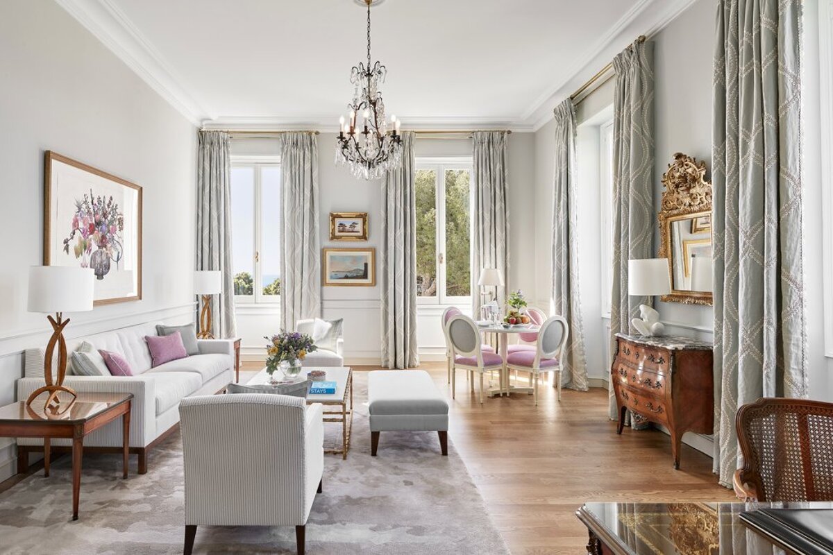 A living room with a couch and chairs and a chandelier
