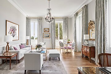 A living room with a couch and chairs and a chandelier