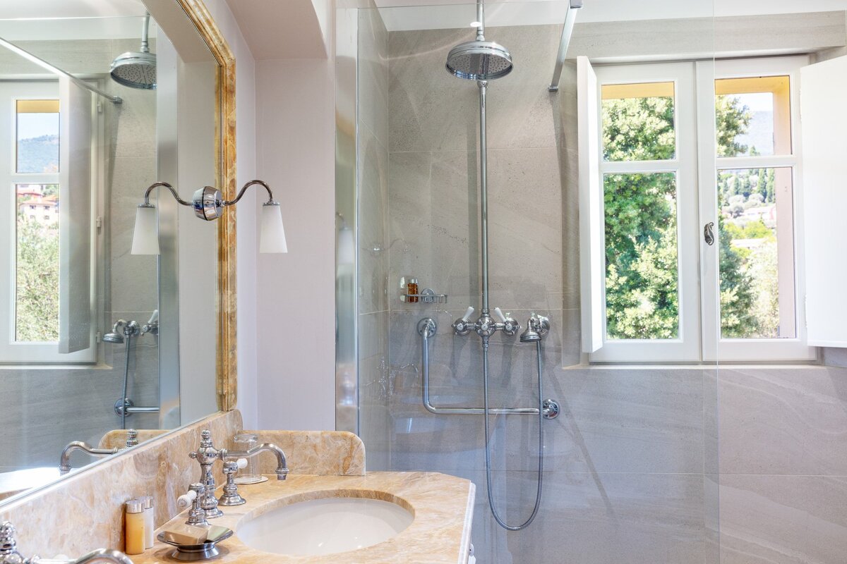 A bathroom with a sink and a shower with a window