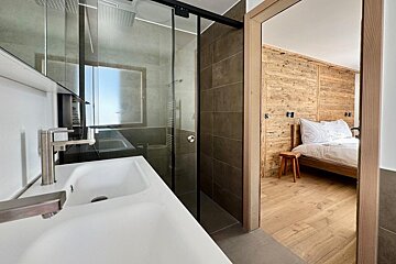 A bathroom with a sink and a walk in shower