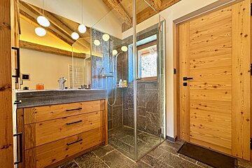 A bathroom with a sink and a walk in shower