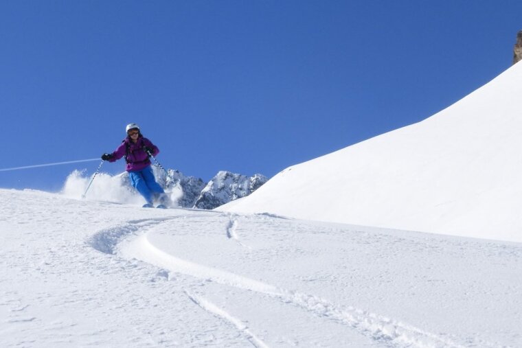 a skier in a purple jacket