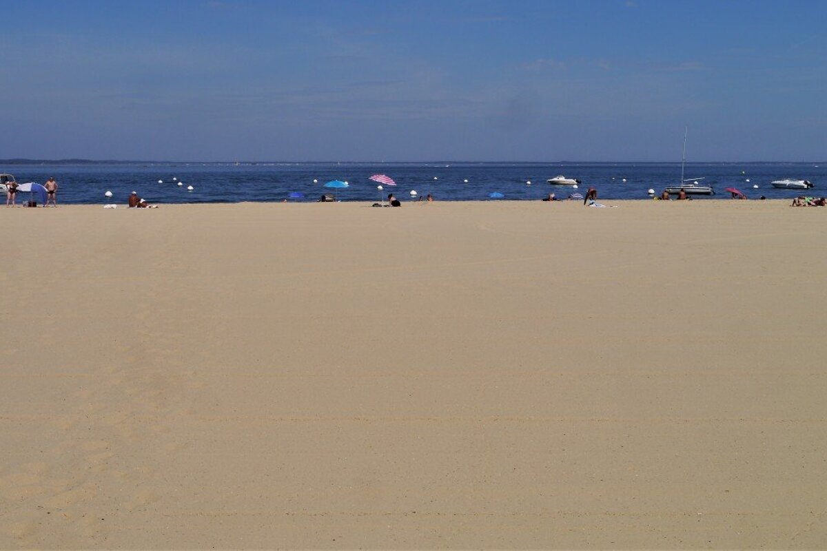a large stretch of beach & blue water