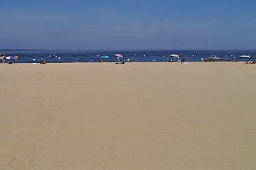 a large stretch of beach & blue water