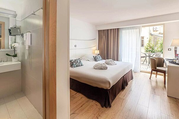 A hotel room with a large bed and a balcony