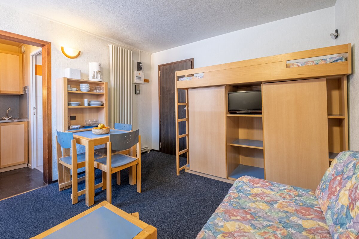 A living room with a bunk bed and a flat screen tv