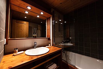 A bathroom with a sink a mirror and a bathtub