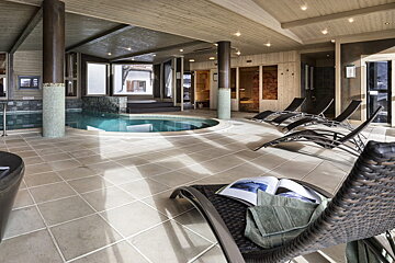 An indoor swimming pool with chairs and a book on a chair