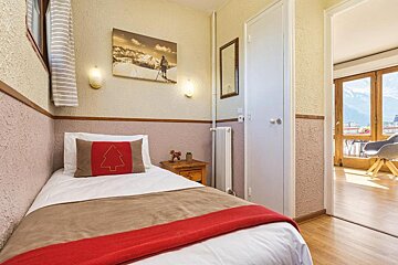 A bedroom with a single bed and a painting on the wall