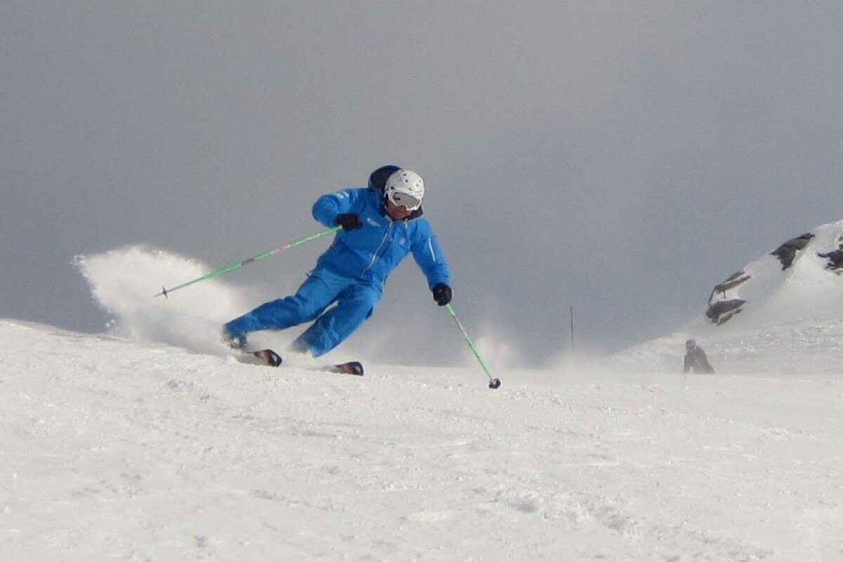 a man in blue skiing down a piste