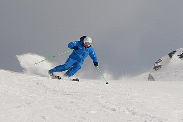 a man in blue skiing down a piste