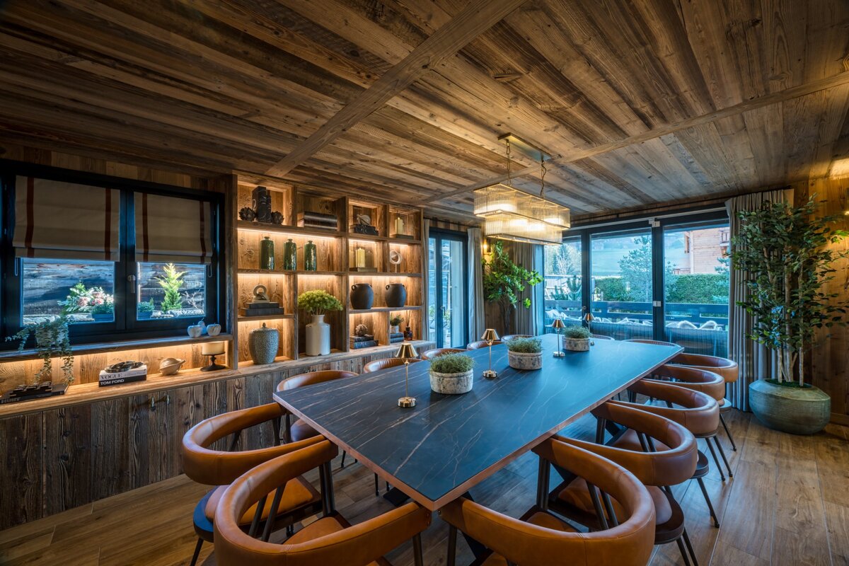 A dining room with a long table and chairs