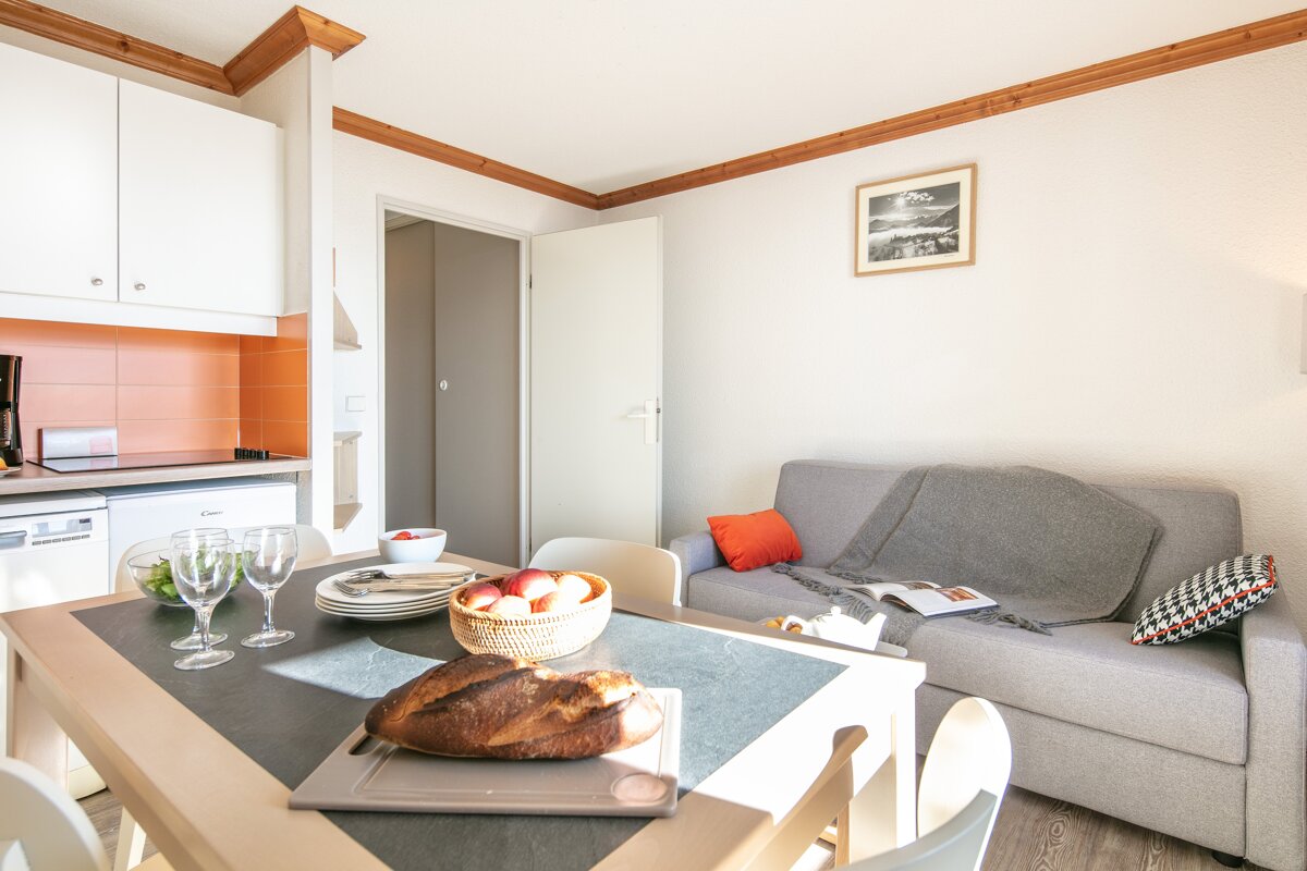A living room with a couch and a table with a loaf of bread on it