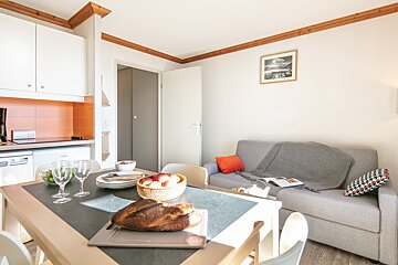 A living room with a couch and a table with a loaf of bread on it