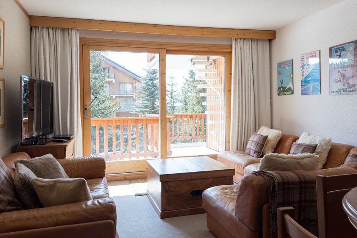 A living room with a couch a chair and a television