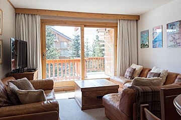 A living room with a couch a chair and a television