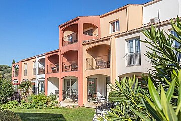 A row of buildings with balconies and chairs on them