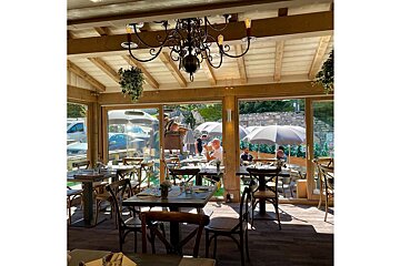 A restaurant with tables and chairs and a chandelier hanging from the ceiling
