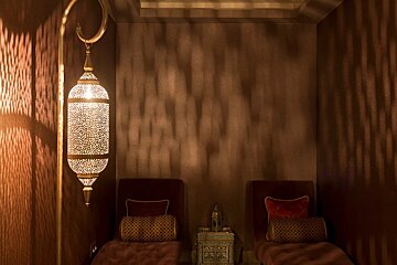 A room with two chairs and a lantern on the wall