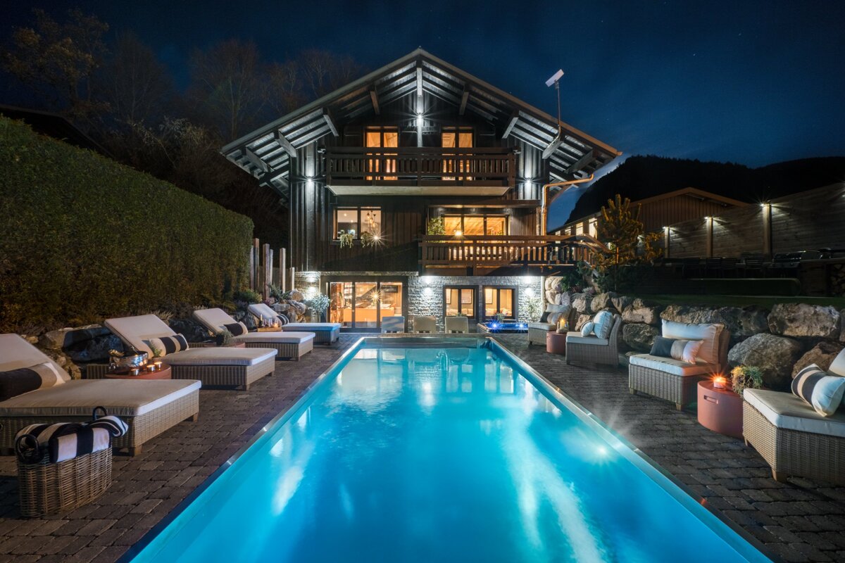 A large house with a swimming pool in front of it