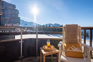 A chair with a yellow pillow that has mountains on it