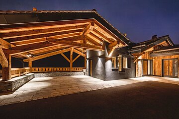 A house with a wooden roof is lit up at night