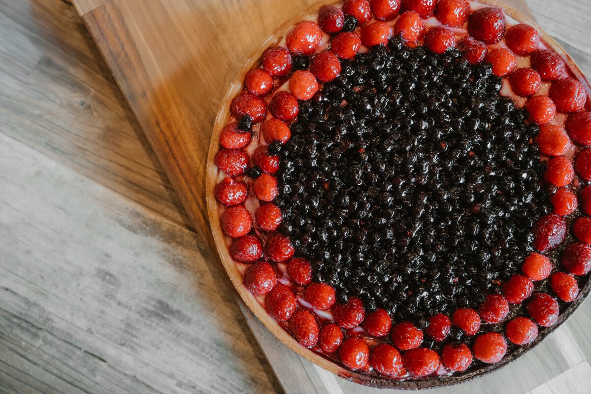 A pie with strawberries and blueberries on top of it