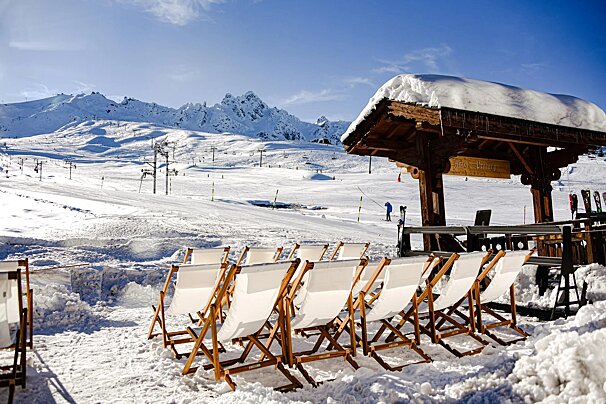 A row of chairs are lined up in front of a wooden structure with a sign on it that says