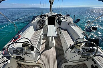 The front of a sailboat with a steering wheel and a table