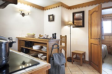 A kitchen with a pot on the stove and a picture on the wall