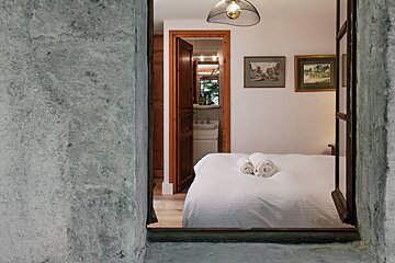 A bedroom with a bed and paintings on the wall