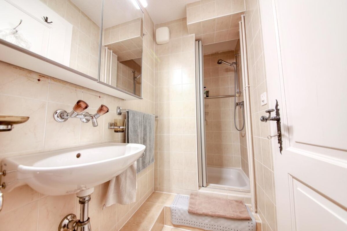 A bathroom with a sink and a shower stall