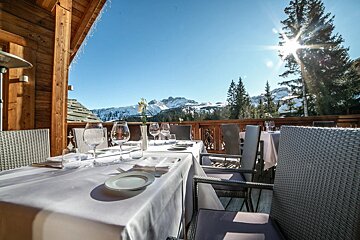 A table set for a meal with mountains in the background