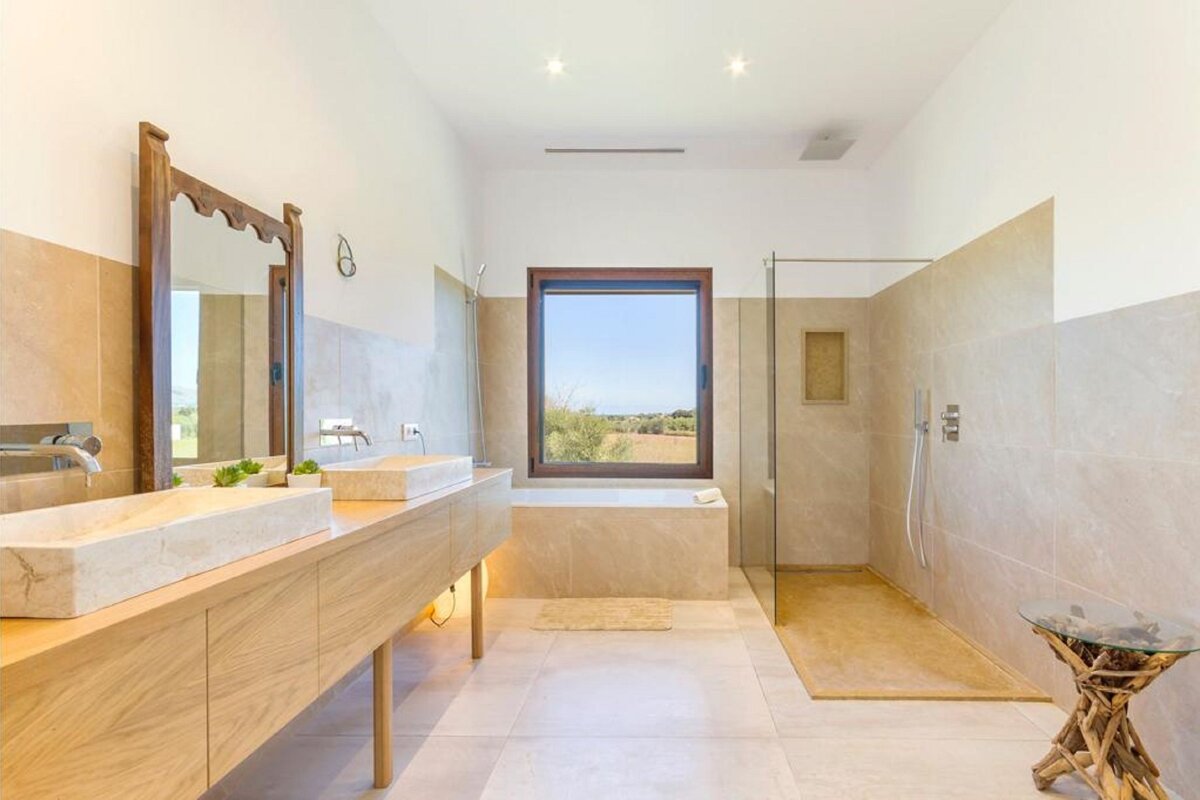 A bathroom with two sinks and a walk in shower