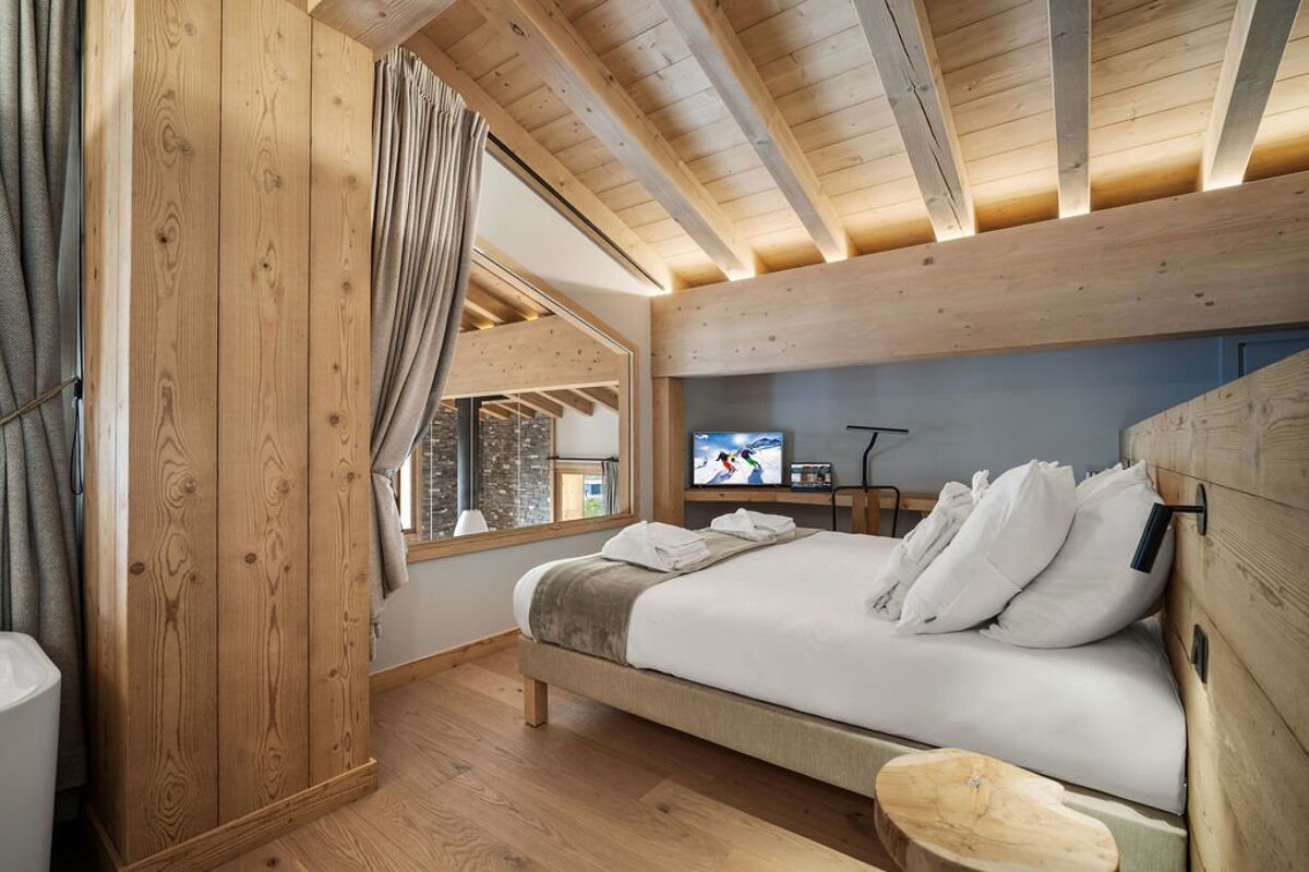 A bedroom with a bed and a flat screen tv