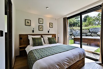 A bedroom with a large bed and a sliding glass door