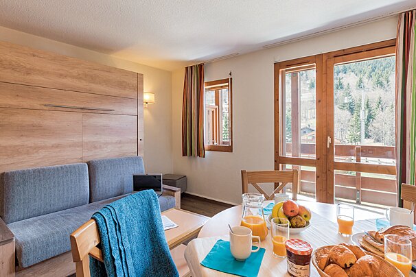 A living room with a couch and a dining table