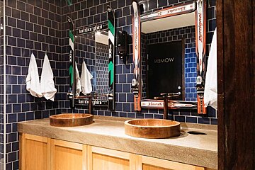 A bathroom with two sinks and a mirror with skis on it