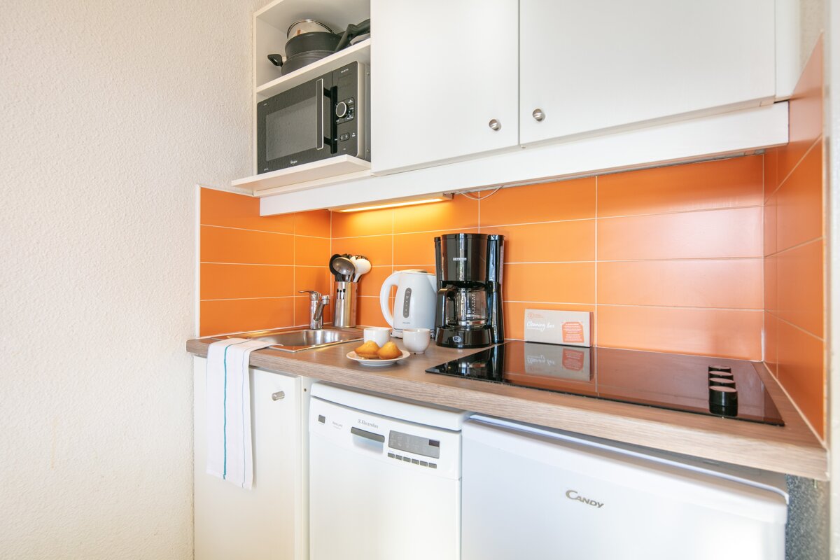 A small kitchen with a candy brand refrigerator