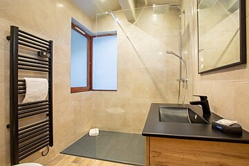 A bathroom with a black towel rack and a black sink