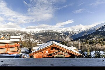 A view of a snowy mountain range from a balcony