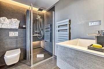 A bathroom with a toilet a sink and a walk in shower