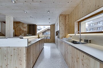 A kitchen with wooden cabinets and white counter tops