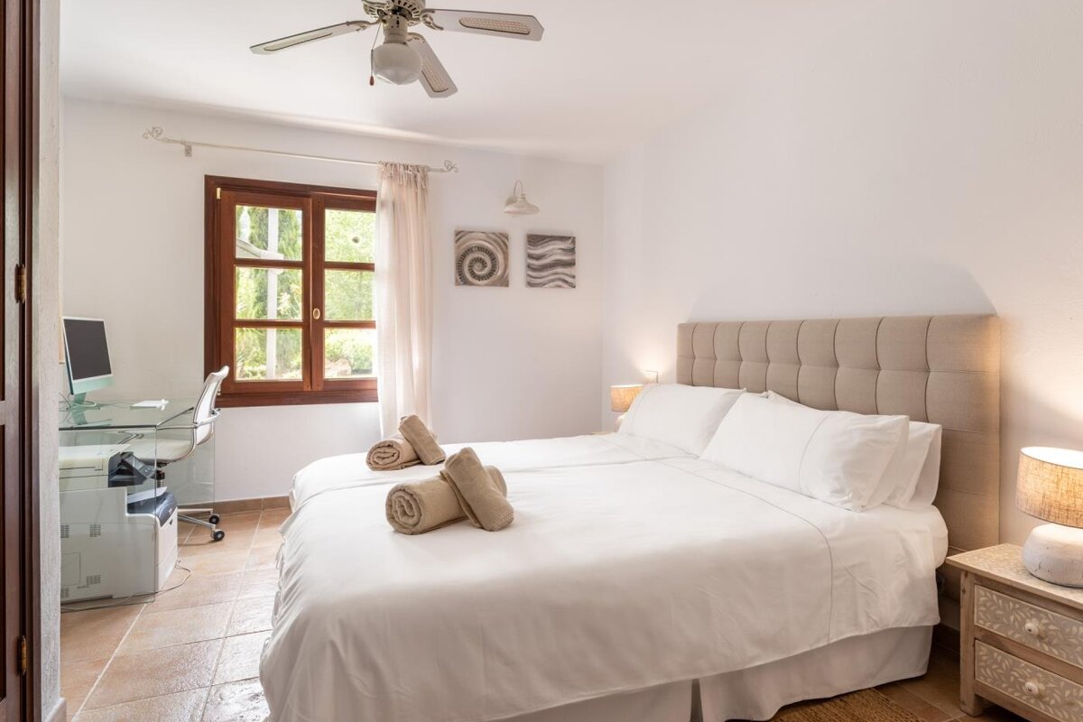 A bedroom with two beds and a ceiling fan