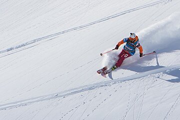 A person skiing with the number 18 on their pants
